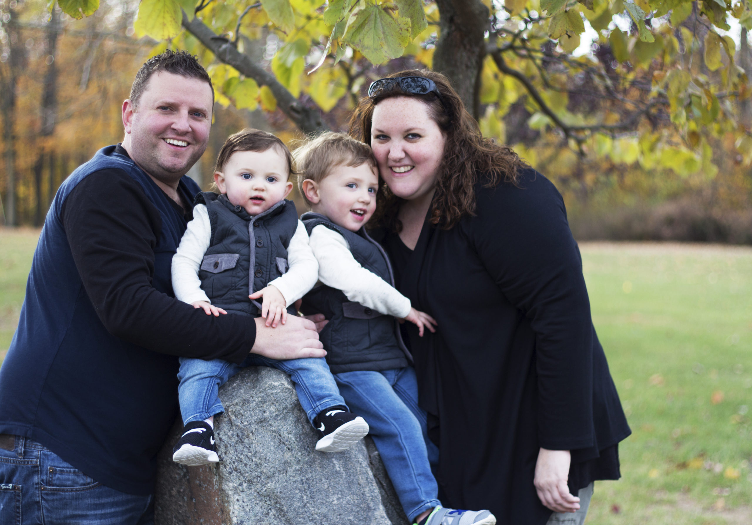 Family of four smiling together at their family photo session.
